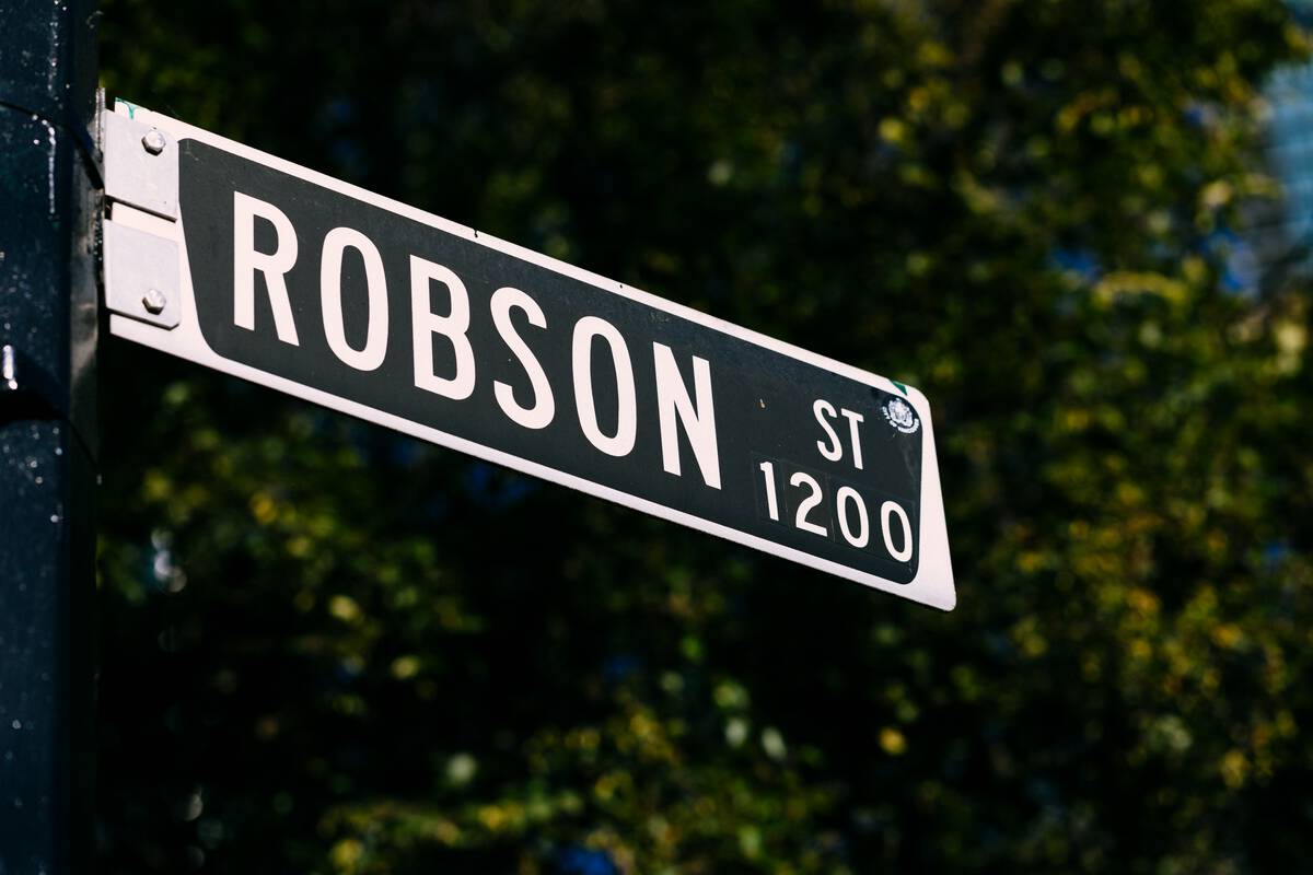 Photograph of black and white street sign with words