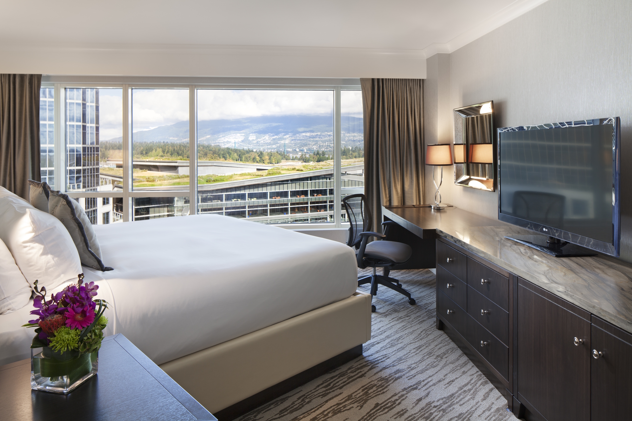 image of bedroom and view from a Deluxe Partial Harbour guestroom
