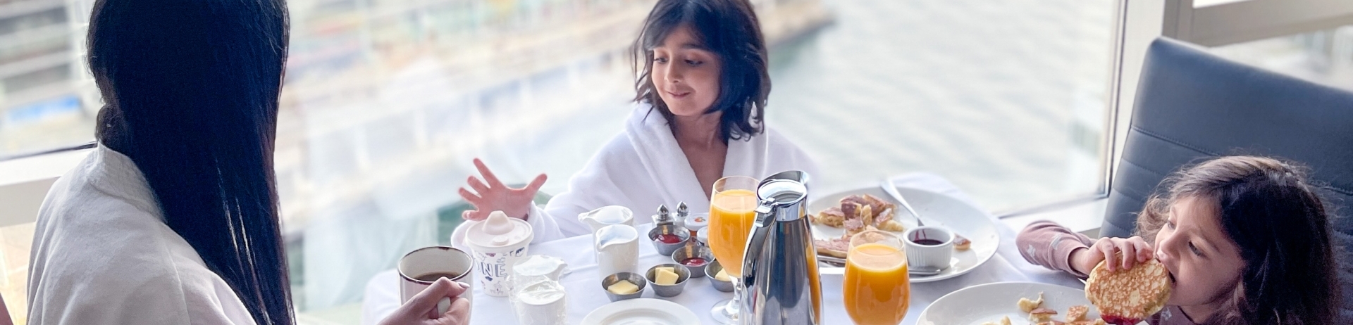 A family of three eating breakfast with a view.