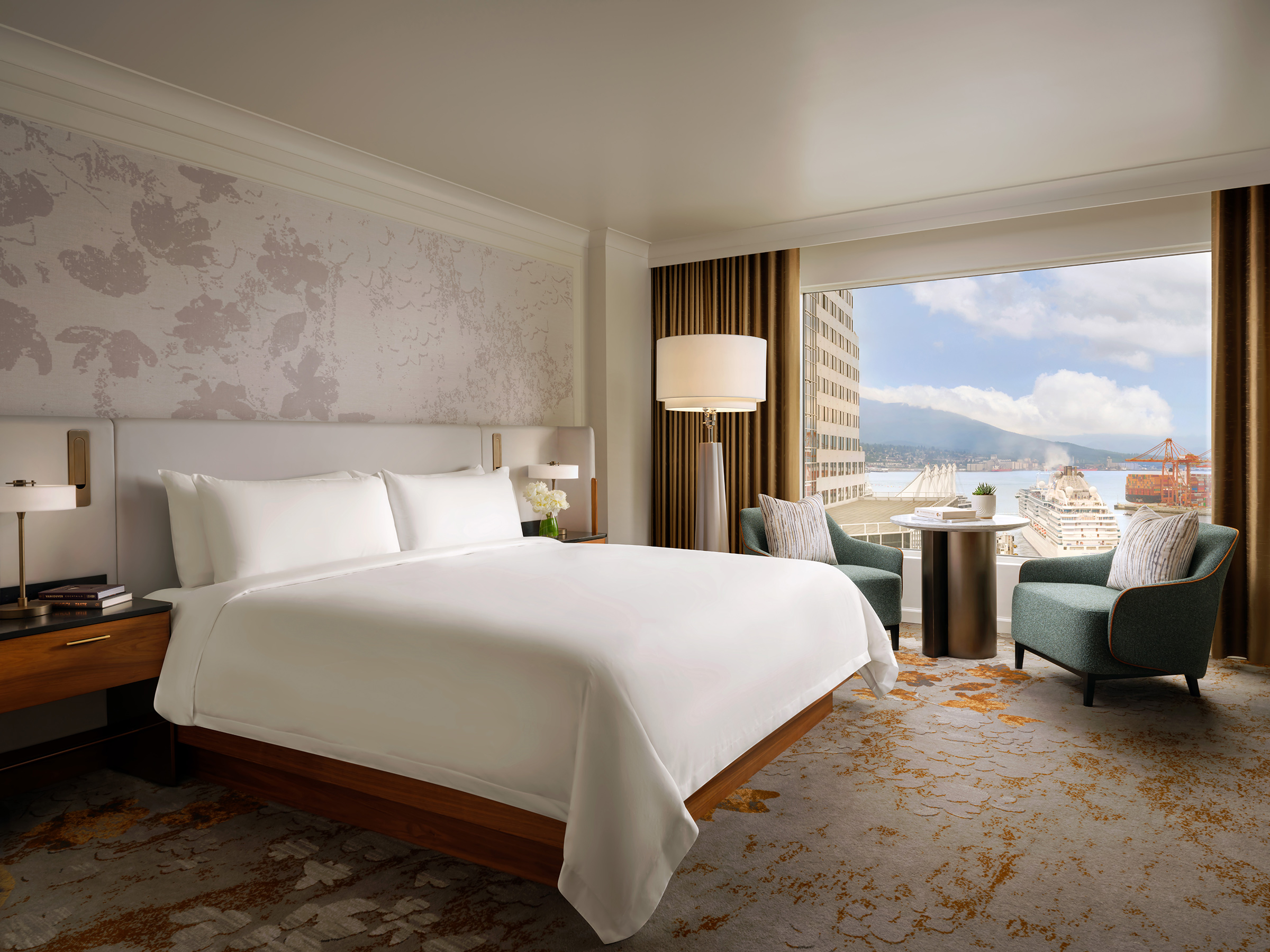 Newly renovated guestroom at Fairmont Waterfront featuring modern coastal design, king bed, and expansive harbour views through floor-to-ceiling windows, showcasing Vancouver’s waterfront and natural light-filled interiors.