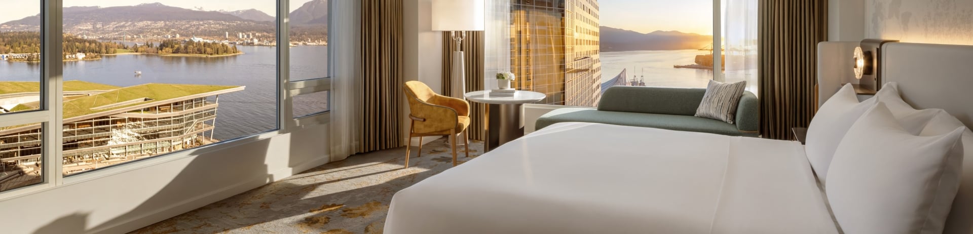 Newly renovated guestroom at Fairmont Waterfront featuring modern coastal design, king bed, and expansive 180 degree harbour views through floor-to-ceiling windows , showcasing Vancouver’s waterfront and natural light-filled interiors.