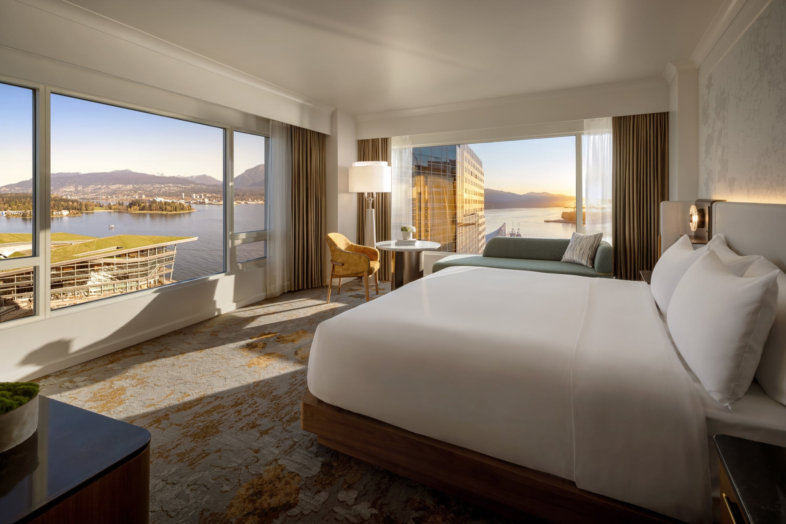 Newly renovated guestroom at Fairmont Waterfront featuring modern coastal design, king bed, and expansive 180 degree harbour views through floor-to-ceiling windows , showcasing Vancouver’s waterfront and natural light-filled interiors.