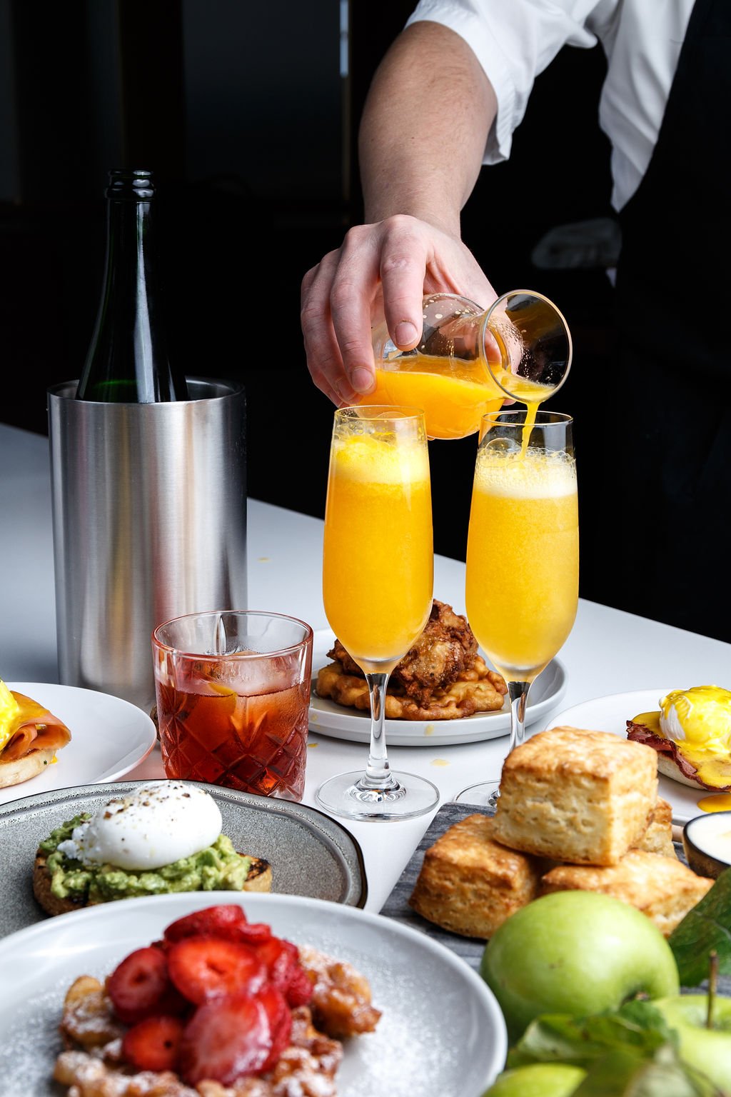 Brunch with mimosas being poured