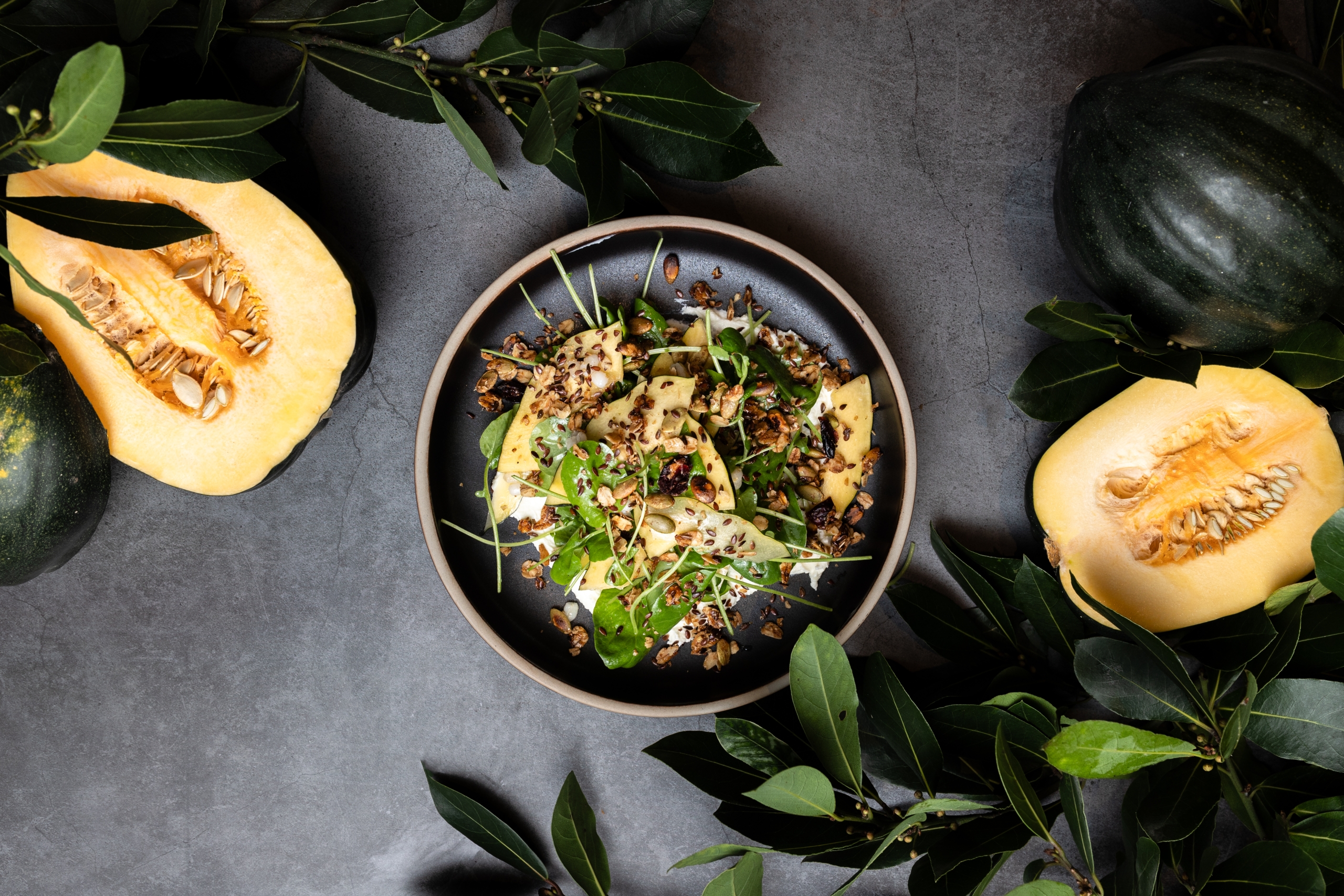 flatlay photo of dish with roasted squash salad with cut squashes and foliage surrounding table