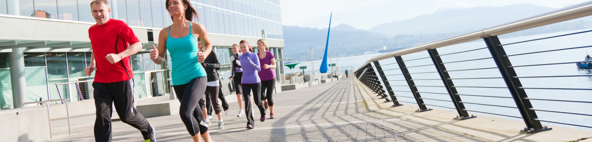 a group of joggers running around the seawall.