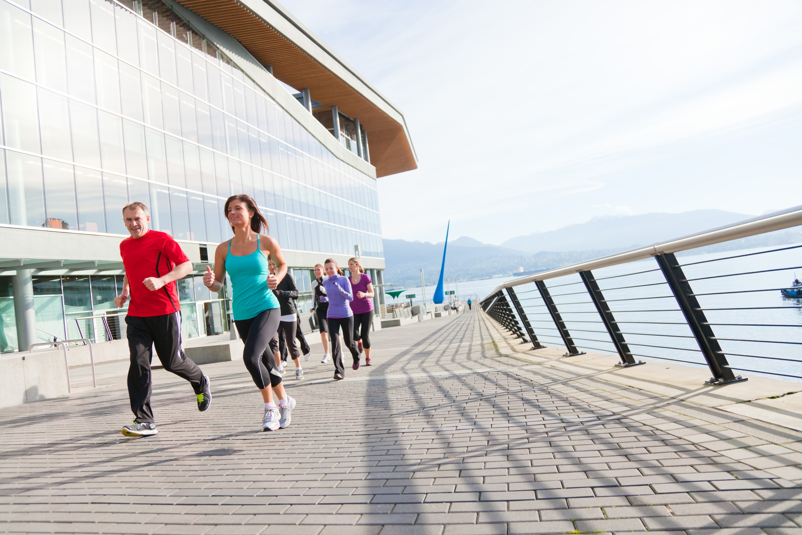 a group of joggers running around the seawall.