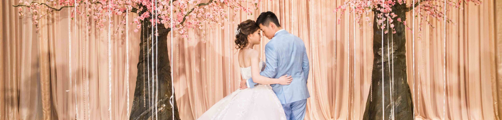 Young bridal couple with cherry blossoms behind them
