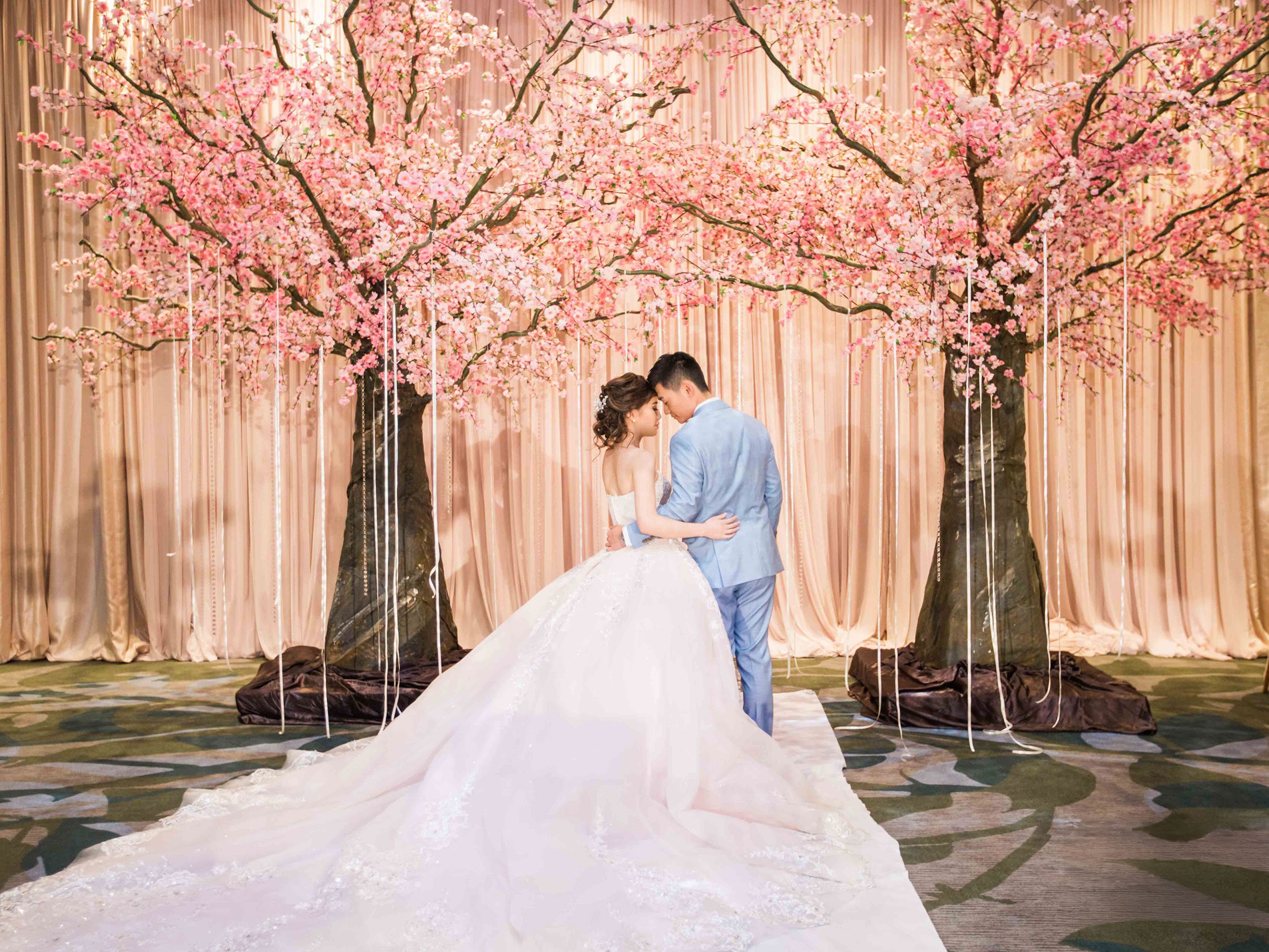 Young bridal couple with cherry blossoms behind them