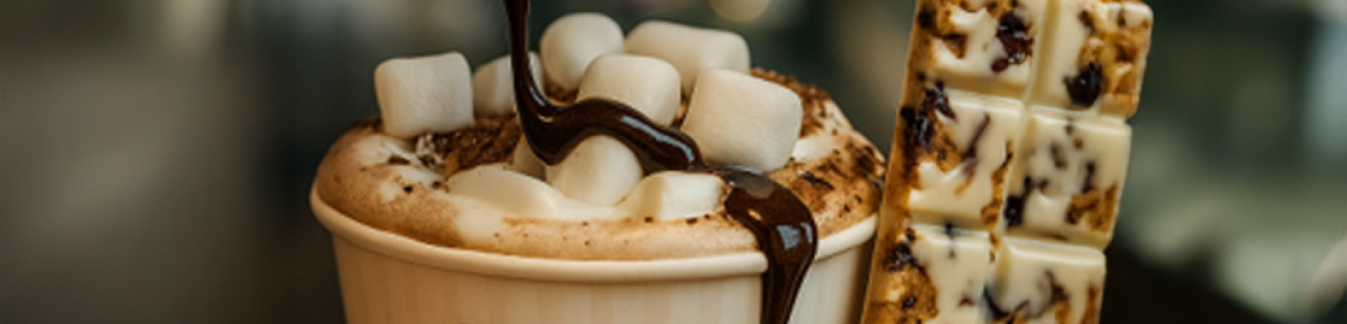 A cup of hot chocolate with chocolate being drizzled over the top.