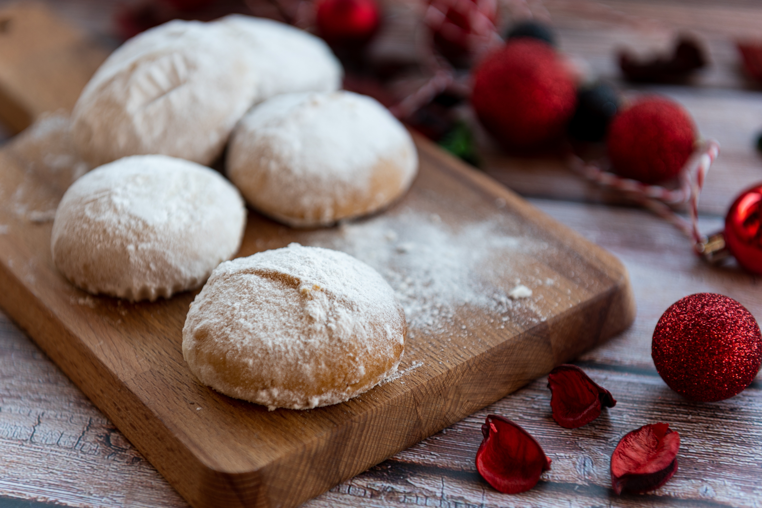 a cutting board with Kourabiedes cookies on top