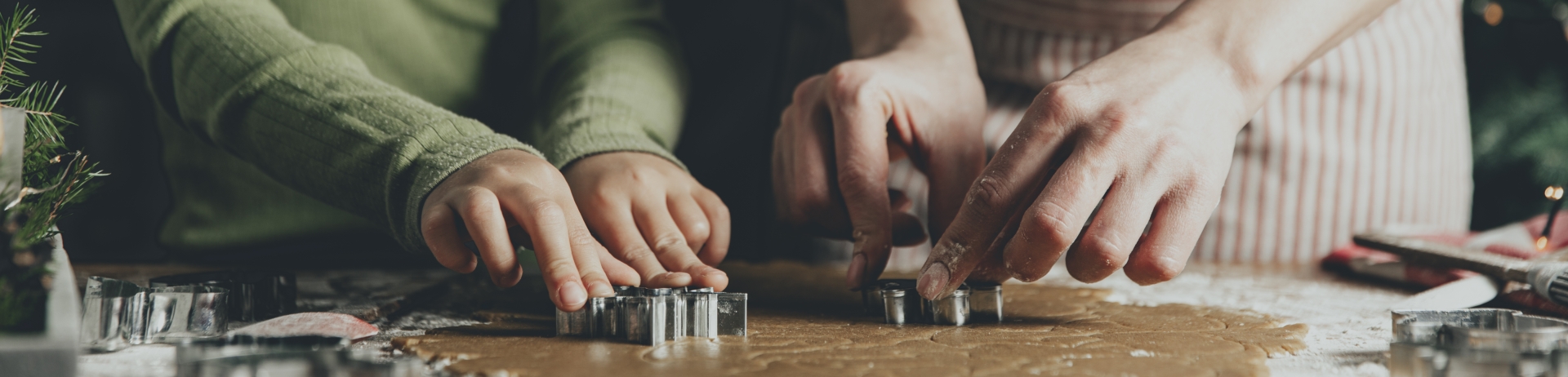 Merry Christmas, Happy New Year. Gingerbread cooking, baking. Mom and daughter make cookies, cut out different shapes of cookies using cutting metal mold on wooden table at kitchen. High quality photo