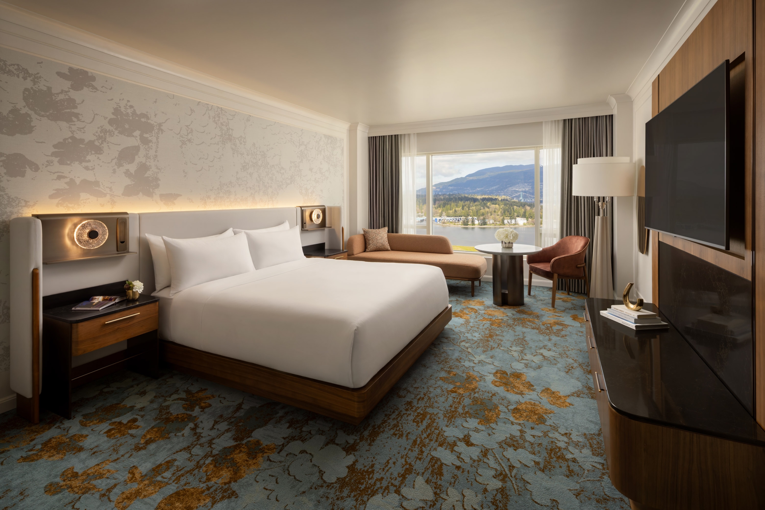 Newly renovated guestroom at Fairmont Waterfront featuring modern coastal design, king bed, and expansive harbour views through floor-to-ceiling windows, showcasing Vancouver’s waterfront and natural light-filled interiors.