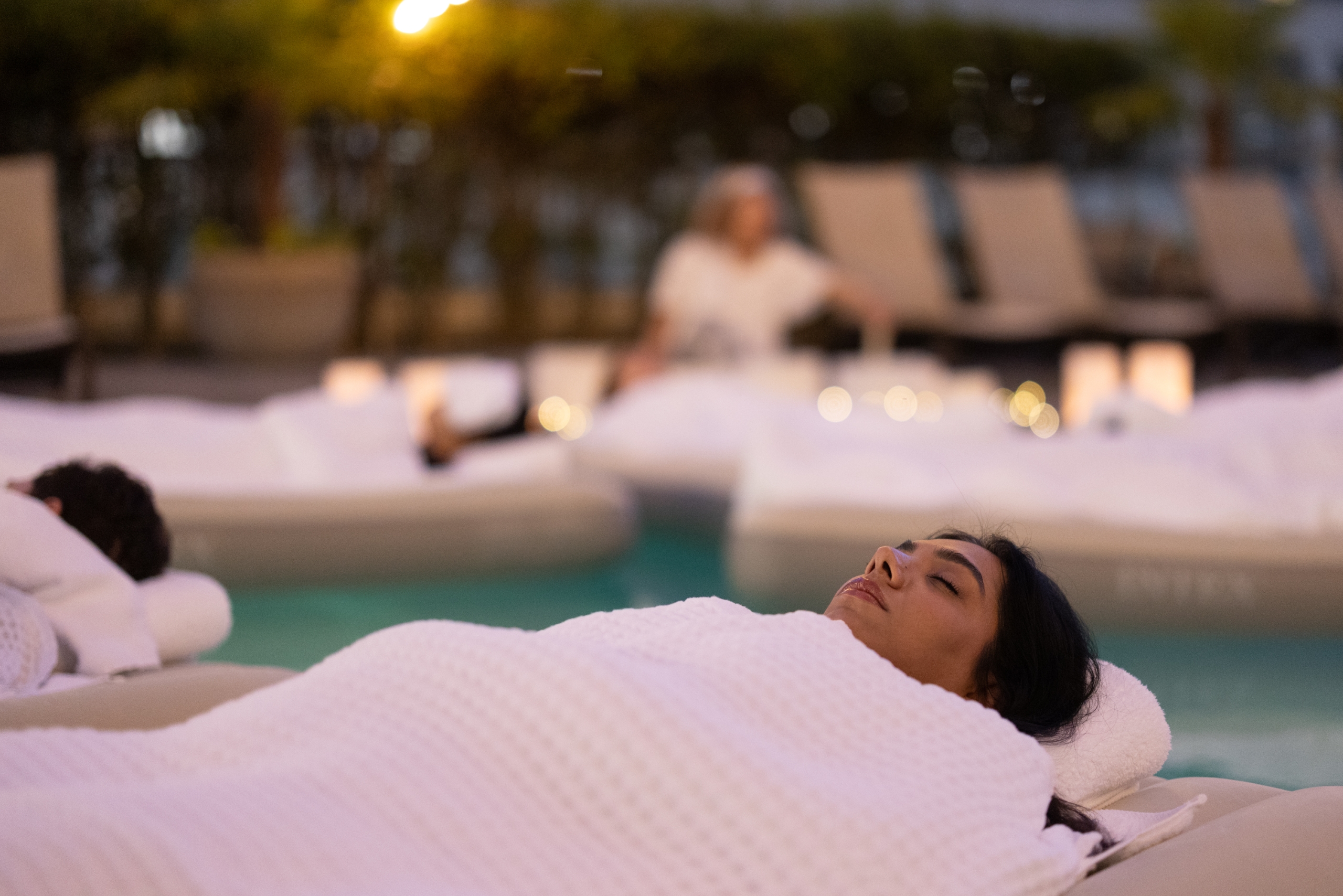 A Fairmont Waterfront guests floating in pool for guided sound bath wellness experience.